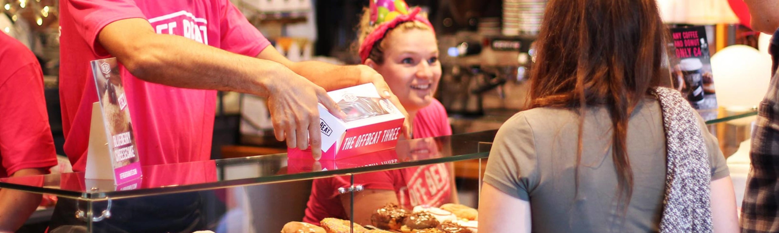 Offbeat Donut's employee serving a costumer