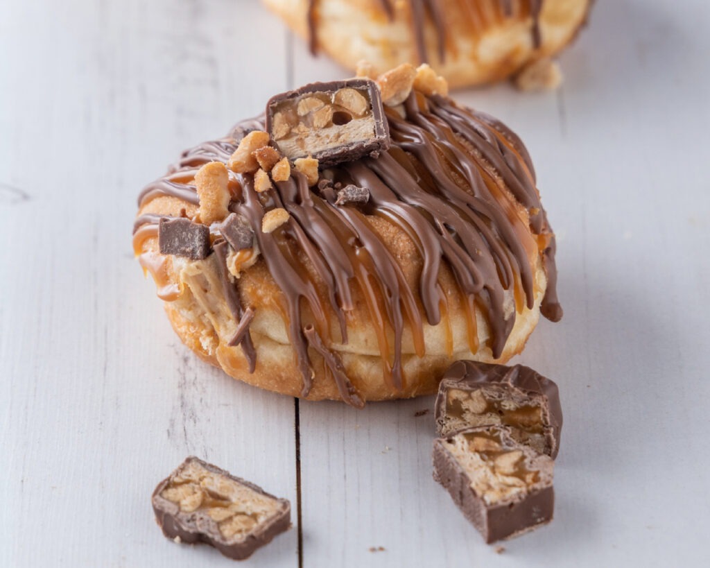 Donut split down the middle, filled with a peanut and caramel creme